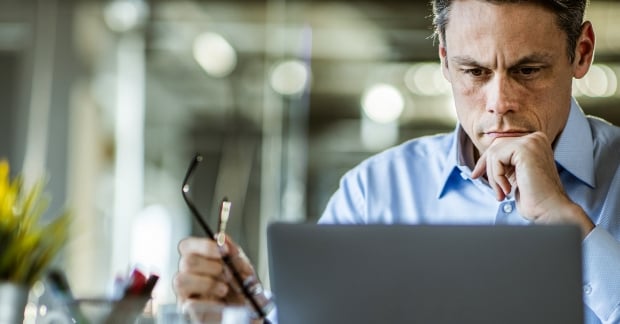 Man pensively looking at computer