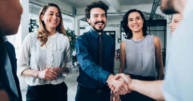 Business partners shaking hands in office setting